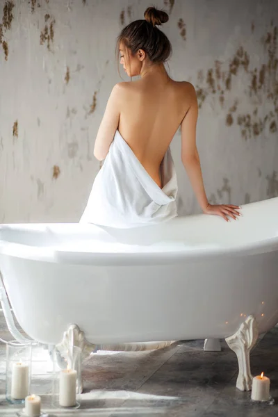 Hát Nézd szép lány, aki rendelkezik az magát csomagolva fehér törülközőt fürdő előtt portréja — Stock Fotó