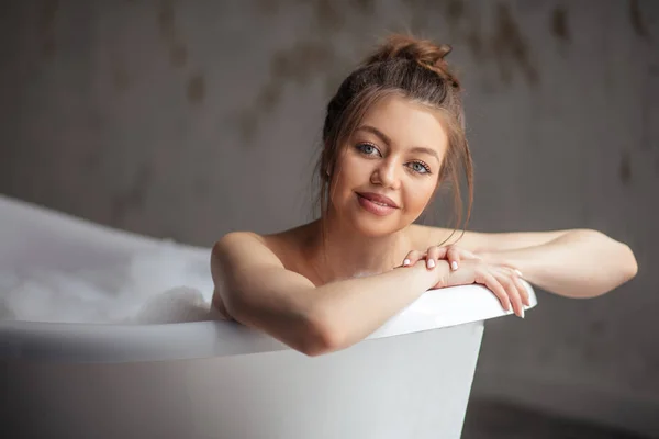 Щаслива жінка лежить у ванні і дивиться на камеру — стокове фото
