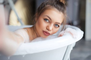 dolgun dudaklar kendini resimleri banyo güzel kahverengi saçlı kızla. yakın çekim fotoğraf. Selfie conceept. Banyoda bir resim çekmek