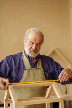 Eski moutache ile saçlı marangoz gri ve ölçüm ahşap oyuncak ev sakal