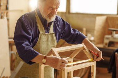 DIY kavramı. Yaşlı adam ahşap evinden kuşlar bir kroki yapmak