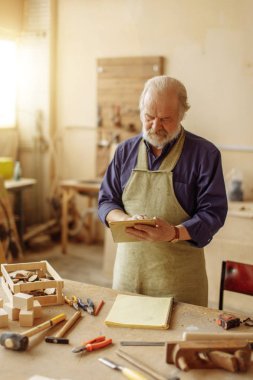Dijital tablet atölye tutarak çalışma üniformalı eski ustası