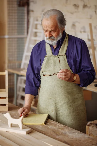 Garaj tabloda yanında durup gözlüklü gelişmiş çağda iyi marangoz