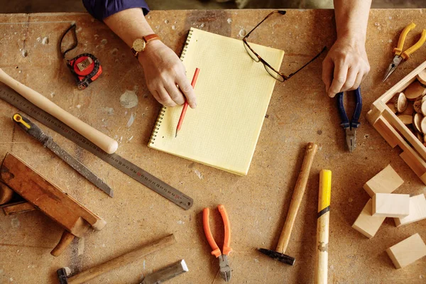 Verschillende timmerman tools liggen op het houten bureau. Top close-up foto. — Stockfoto