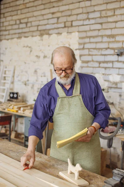 eski gri saçlı marangoz atölyesinde ölçümleri alarak