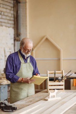 yetenekli kıdemli vatandaş yeni ahşap oyuncak temel bir kroki yapmak