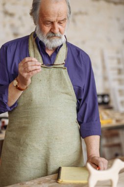 masanın üzerinde yatan alıştırma kitabı bakarak eski işçi