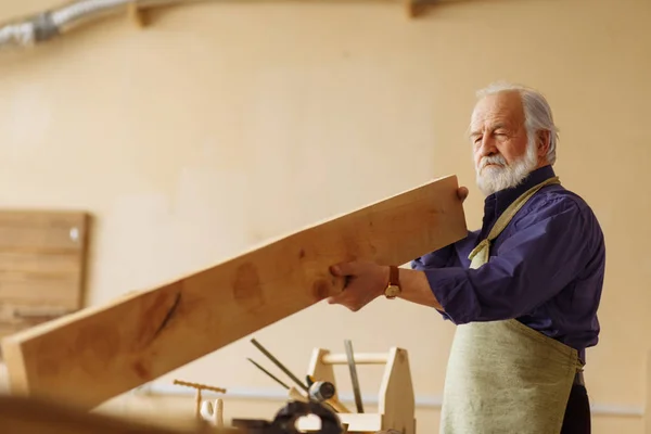 Velho macho roupas especiais usando pranchas na construção na oficina — Fotografia de Stock