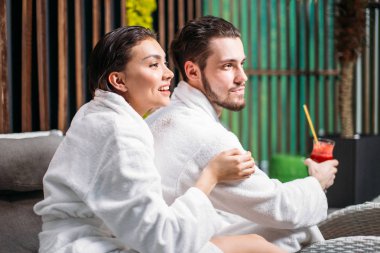 Genç erkek ve dişi tatil zevk suyu ile gülümseyen