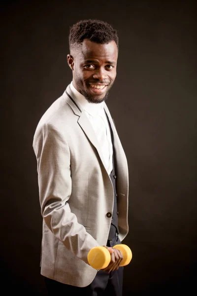 Lachende Afro man met gele dumb-bell — Stockfoto