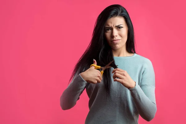 Angry young woman is going to cut hair. — Stock Photo, Image