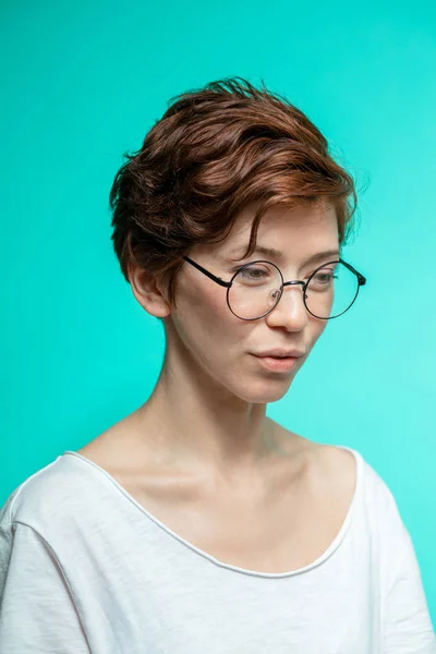 Inteligente mujer pensativa en gafas mirando hacia abajo y hacer un gran plan —  Fotos de Stock