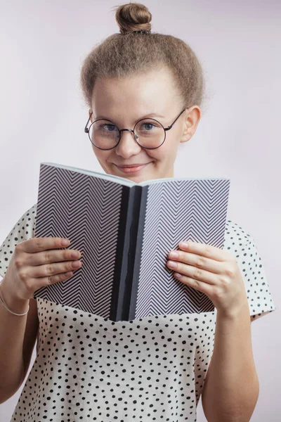 Goed uitziende vrouw met boek op zoek naar camera — Stockfoto