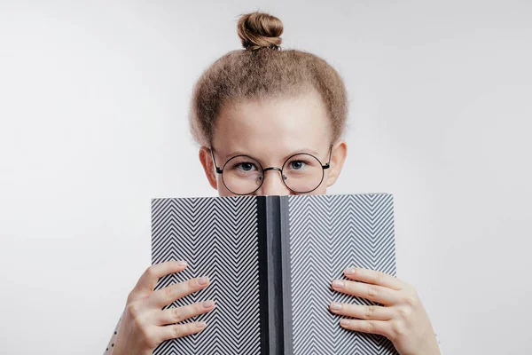 Молода жінка закриває обличчя книгою — стокове фото