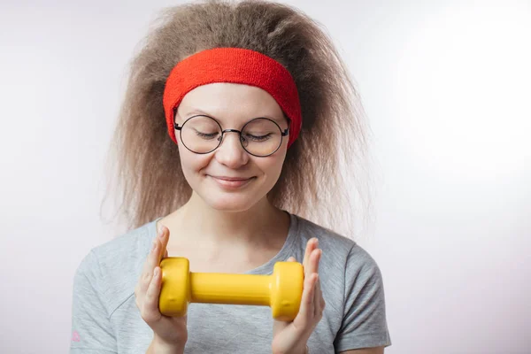 Nahaufnahme Porträt einer fröhlichen jungen Frau mit gelbem Dumbbel in den Händen — Stockfoto