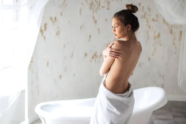 Fille avec corps nu regardant la fenêtre dans la salle de bain — Photo