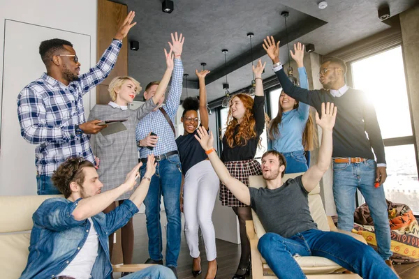 Compañeros de trabajo con los brazos levantados celebrando una reunión exitosa —  Fotos de Stock