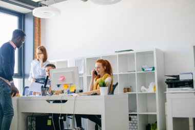 güzel büyüleyici zencefilli kadın oturuyor ve keyifli müşterilerle konuşurken