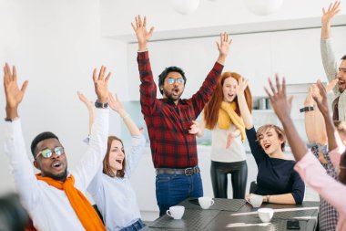 Başarılı genç çok ırklı insanlar ellerini yükselterek ve çığlık