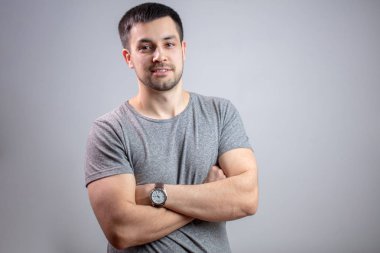 Çapraz kolları olan genç güçlü bir adam portresi