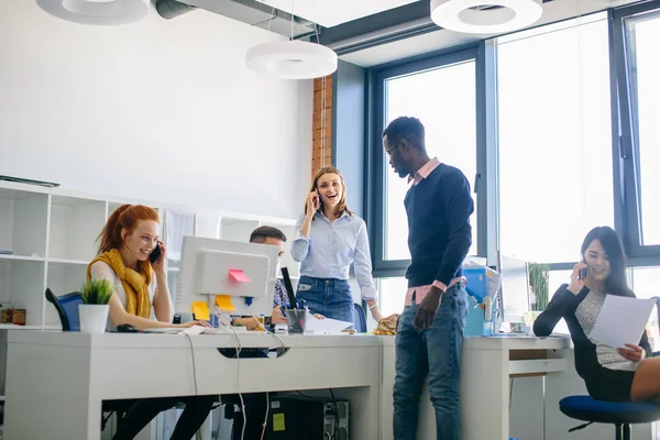 Three female colleagues are sharing with good business news on their cellphones — Stock Photo, Image