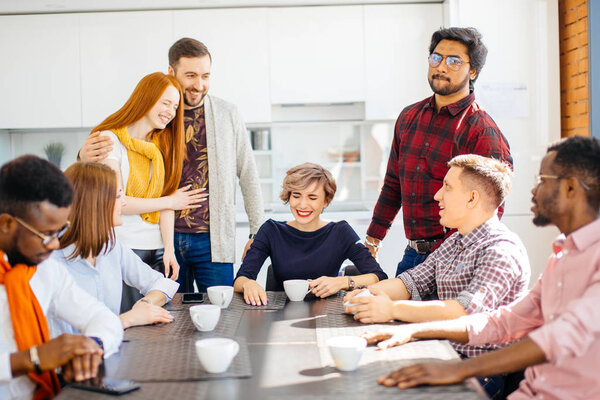 laughing business people telling jokes while drinking tea