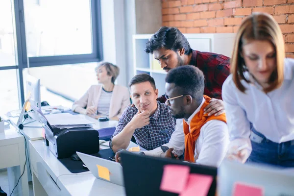 Jonge Hindoo tutor permanent naast zijn collega's en de controle op werk — Stockfoto