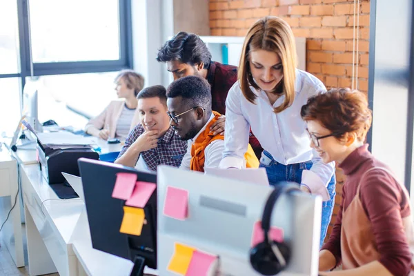 Dos asistentes que ayudan a los nuevos empleados que trabajan con ordenadores y portátiles — Foto de Stock