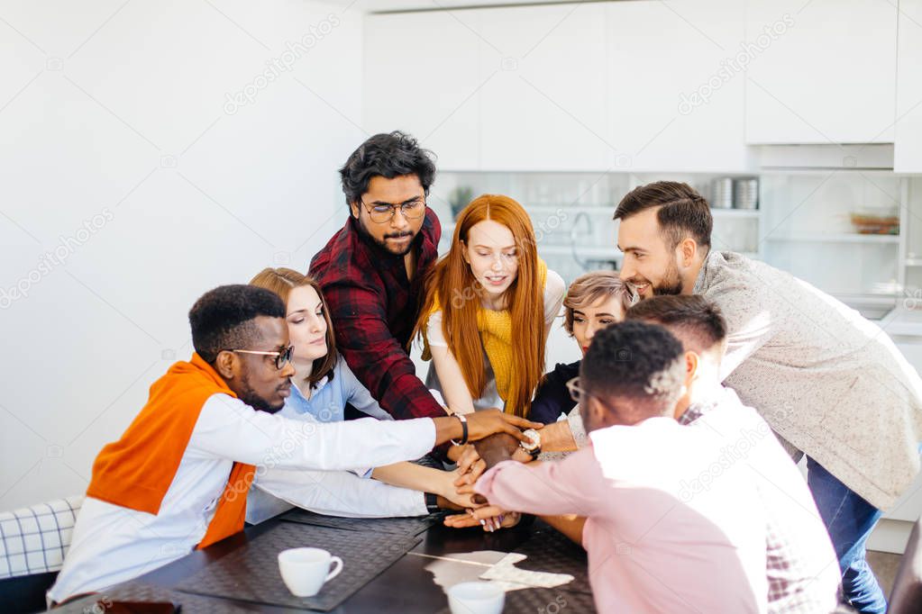 close up image of diverse managers holding hands together