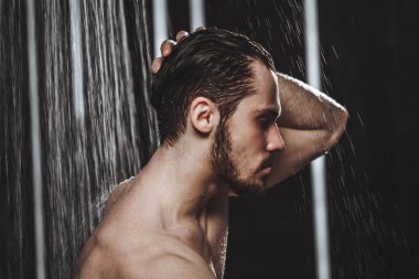 Yakın çekim yan görünümü fotoğraf genç bir adamın duş alıyor