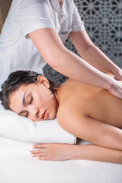 Массажистка делает массаж для привлекательной женщины с болью в спине — стоковое фото