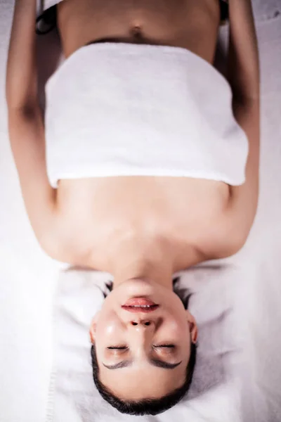 Mladá pěkná žena leží na posteli po získání vydání bylinné rub dolů — Stock fotografie