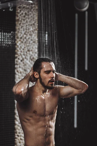 Hombre desnudo con abdominales perfectos es calmar la tensión en el baño — Foto de Stock