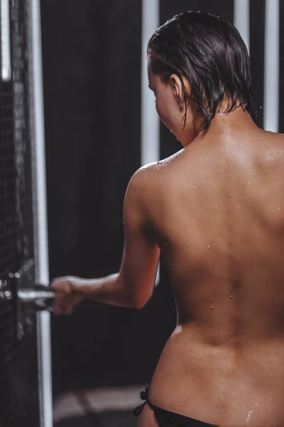 Rückenansicht einer nackten Frau mit Tropfen auf ihrer glatten Haut im Duschbad — Stockfoto