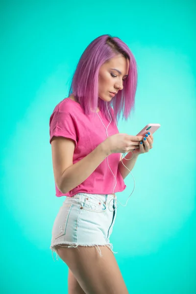 Mujer descargando sus fotos con su nuevo color de pelo rosa a la red social medial . — Foto de Stock