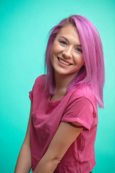 Menina estudante engraçado com cabelo pinl se divertindo ao mostrar a língua . — Fotografia de Stock