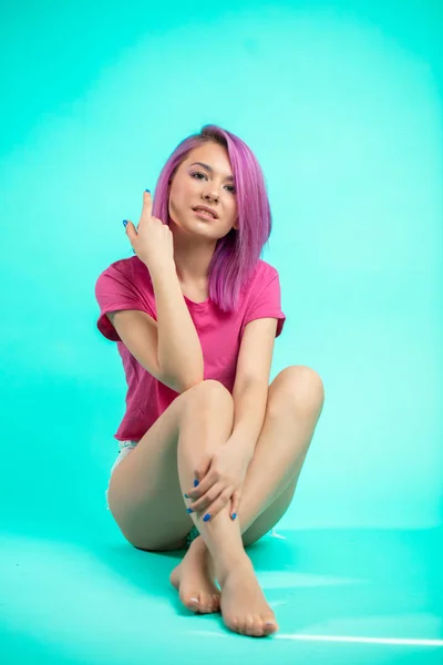 Яркая молодая красивая девушка с розовыми волосами, сидя на полу — стоковое фото