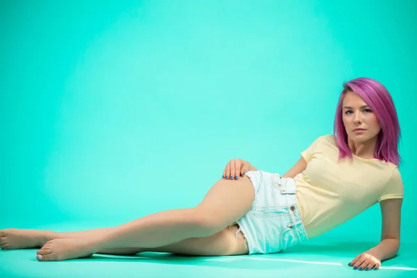 Junge Frau sitzt isoliert auf dem Boden — Stockfoto