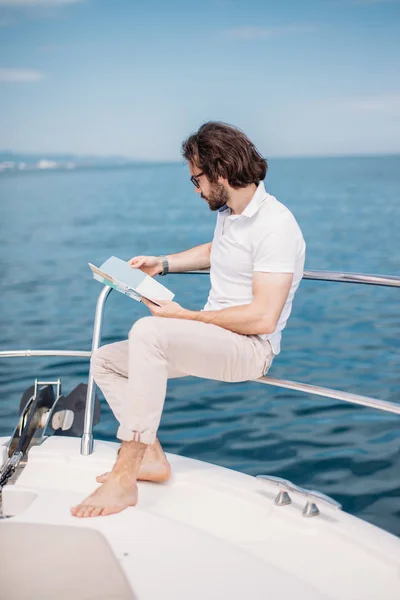 Jovem barbudo em um iate de luxo com uma vista magnífica do mar. — Fotografia de Stock