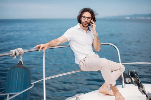 Jonge man met baard op een luxe jacht met een prachtig uitzicht op de zee. — Stockfoto