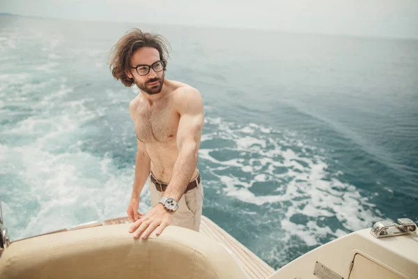 Mann entspannt sich in der Sonne, auf einem Boot auf dem Meer liegend. Luxusurlaub auf einer Jacht auf den Inseln. — Stockfoto