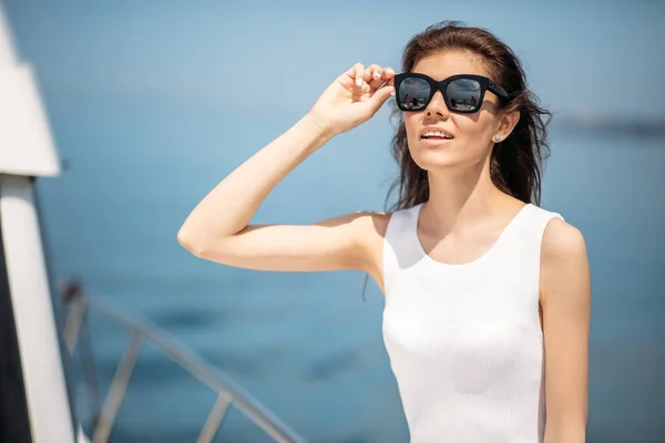 Mulher jovem, atraente e rica tendo fotossesion em um barco de luxo no mar — Fotografia de Stock