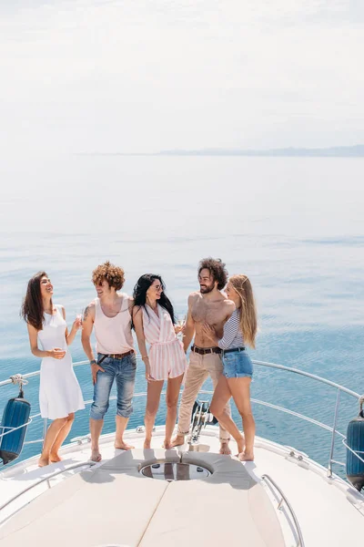 Impreza jachtowa z młodymi ludźmi urządzającymi imprezę na łodzi, tańczącymi na dziobie pokładu jachtowego — Zdjęcie stockowe