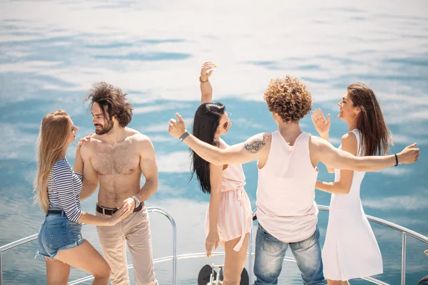 朋友们在远洋的帆船上欢庆的后视镜，举起双臂. — 图库照片