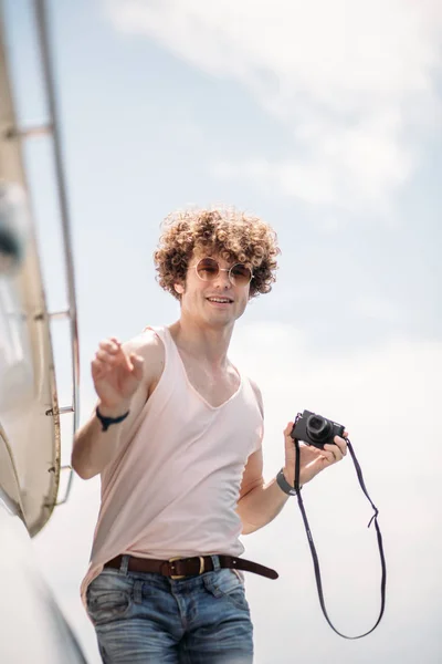 Jovem homem bonito preparando barco para iniciar uma viagem, de pé no barco — Fotografia de Stock