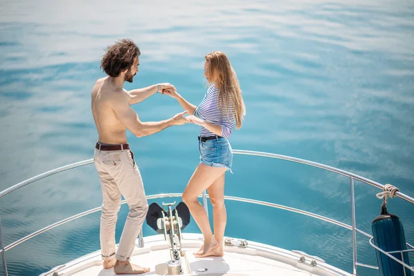 Passionate lovers dancing on bow of deck while sailing on yacht. — Stock Photo, Image