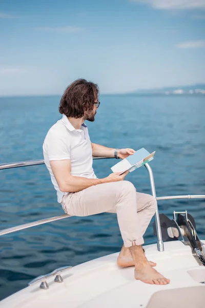 Jovem barbudo em um iate de luxo com uma vista magnífica do mar. — Fotografia de Stock