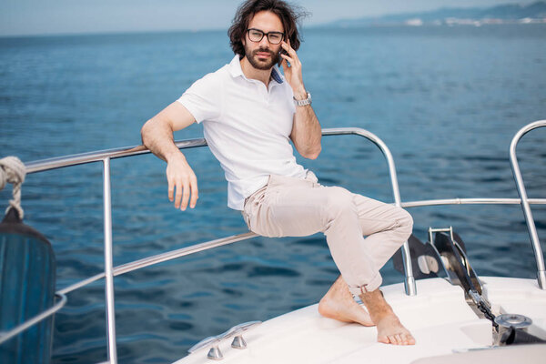 Young bearded man on a luxury yacht with a magnificent view of the sea.