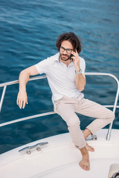 Young bearded man on a luxury yacht with a magnificent view of the sea. — Stock Photo, Image