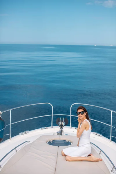 Hermosa morena mujer en vestido blanco posando en barco —  Fotos de Stock